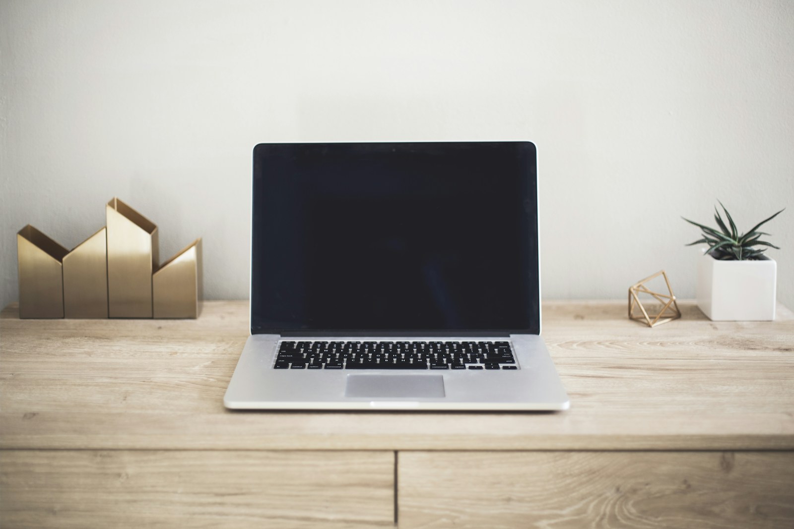 A slim laptop open on a wooden desk